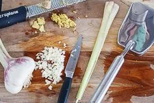 Rotes Thai Curry Zutaten wie Ingwer, Knoblauch und Zitronengras vorbereiten