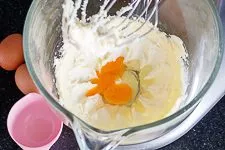 Eier nacheinander in Teig für Erdbeerkuchen mit Mascarpone-Creme rühren