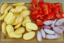 Vorbereitete Kartoffeln, Paprika und Schalotten für Ofengemüse vom Blech