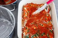 Spinatlasagne in der Form schichten