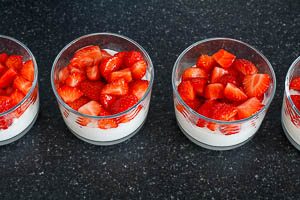 Quark-Konfekt-Masse und Erdbeeren in die Gläser schichten