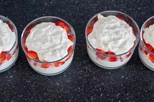 Mit einer Schicht Kokos-Konfekt-Masse abschließen und mit Kokosraspeln bestreuen