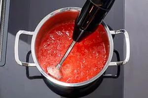 Erdbeeren mit Pürierstab oder Kartoffelstampfer im Topf pürieren