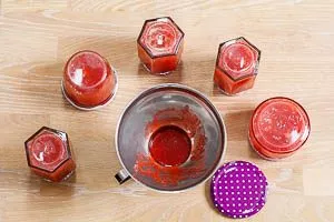 Erdbeermarmelade in sterilisierte Gläser füllen
