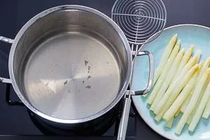Spargel frisch gekocht aus dem Kochtopf gehoben.