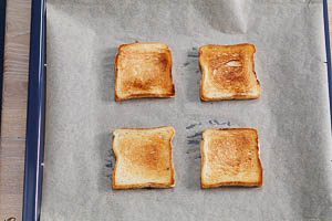 Toastbrotscheiben auf Backpapier im Backblech