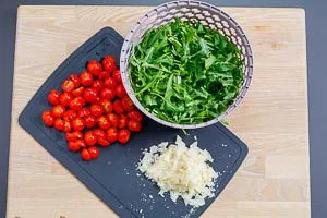 Rucola, Kirschtomaten und gehobelten Parmesan für Rucola-Salat vorbereiten