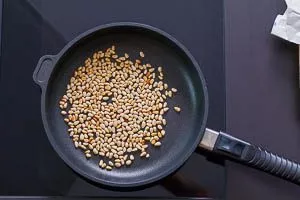 In der Pfanne goldbraun angeröstete Pinienkerne für Spaghettisalat