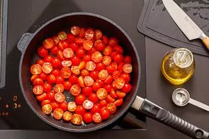 Tomaten zubereiten in der Pfanne für Burrata Pasta