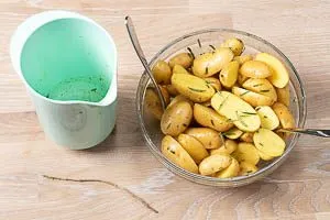 Kartoffeln mit der Marinade und dem Rosmarin vermengen