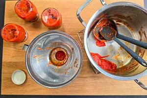 Selbstgemachten Ajvar in Gläser abfüllen