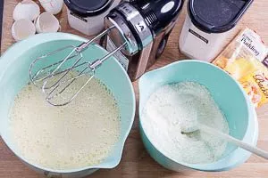 Trockene und flüssige Zutaten für den Blechkuchen jeweils in Schüsseln vermengen