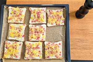 Den Flammkuchen Belag auf die Toast streichen