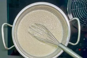 Grieß mit einem Schneebesen in die Milch einrühren