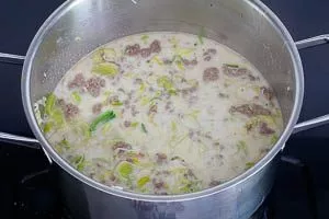 Zutaten mit Gemüsebrühe und Sahne ablöschen