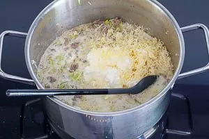 Käse-Mischung in der Suppe vermengen