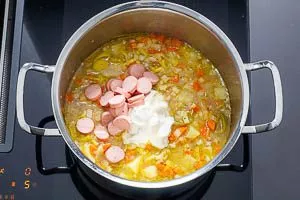 Kartoffelsuppe mit Würstchen und Créme Fraîche verfeinern