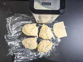 Arbeitsplatte bestäuben und Teig vierteln