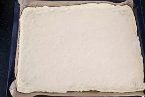 Den Zwiebelkuchen Boden aufs Backblech