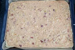 Die Zwiebelkuchen-Masse auf das Backblech verteilen