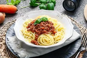 Bolognese-Soße mit Spaghetti auf einem Teller angerichtet servieren