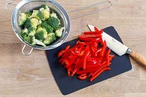 Brokkoli und Paprikaschote für das Curry-Gericht schneiden