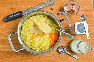 Eigelbe, Butter und Gewürze zur Kartoffelmasse hinzugeben