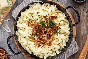 Käsespätzle mit Röstzwiebeln und Schnittlauch garnieren