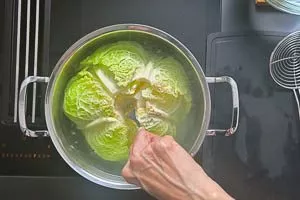 Ganzen Wirsing in einem Topf tauchen, die Blätter lösen sich dann selbstständig.