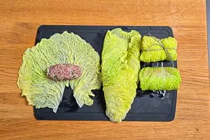 Hackfleisch in die Mitte geben, die Kohlroulade aufrollen und mit Küchengarn zu einem Päckchen schnüren.