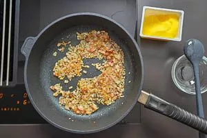 Zwiebeln und Speck anschwitzen.
