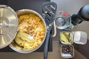 Sauerkraut zu den würzigen Zutaten in den Topf geben