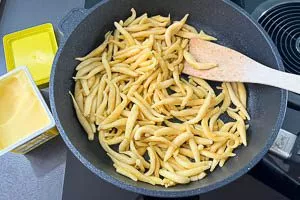 Schupfnudeln in Butterschmalz von allen Seiten goldbraun braten.