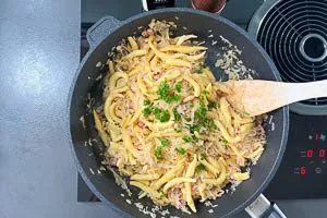 Gebratene Schupfnudeln zugeben und mit Schnittlauchröllchen garnieren.
