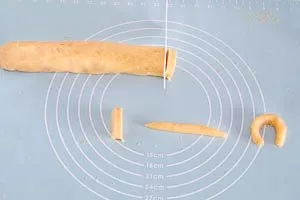 Aus den Rollen Scheiben schneiden und Vanillekipferl formen.