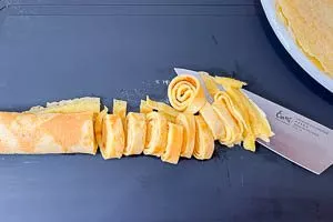 Pfannkuchen eng rollen und in Streifen schneiden.