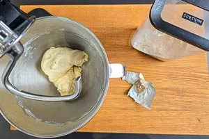 Hefe und Weizenmehl mit den feuchten Naan-Zutaten verkneten