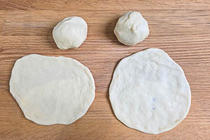 Kugeln aus Naan-Brot-Teig flachdrücken