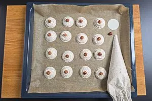 Baiser auf die Oblaten auf Backpapier spritzen