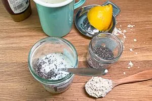 Haferflocken, Milch, Zitronensaft, Chiasamen und Honig im Schraubglas