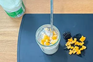 Obst oder Beeren und Joghurt zu den Overnight Oats ins Glas geben