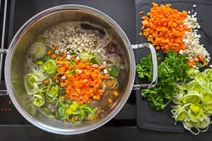 Möhren, Lauch, Sellerie und Petersilie in der Suppe mit Rindfleisch kochen