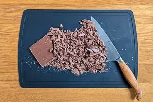 Die Schokolade in grobe Stücke hacken.