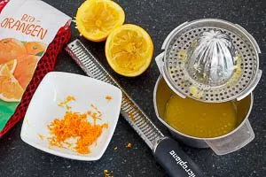 Schale der Orange reiben und Saft auspressen.
