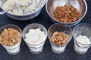 Creme und Spekulatius-Brösel schichten.