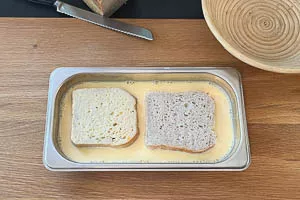 Weißbrotscheiben in Ei-Milch-Mischung legen
