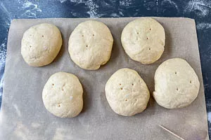 Löcher in die Teiglinge machen.