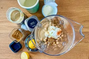 Kichererbsen mit Tahin, Olivenöl, Joghurt, Knoblauch, Zitrone, Kreuzkümmel, Salz und Cayennepfeffer in den Mixer geben