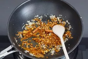 Ingwer, Knoblauch und Gewürze in der Pfanne andünsten