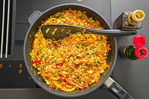 Nasi-Goreng-Zutaten mit Reis in der Pfanne anbraten